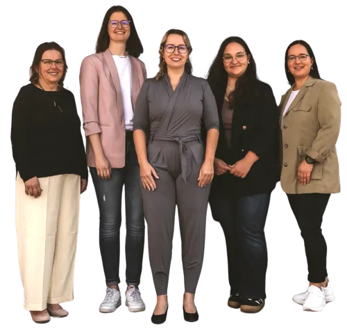 Team der Logopädischen Praxis Nadine Siebensohn lächelnd vor der Praxis